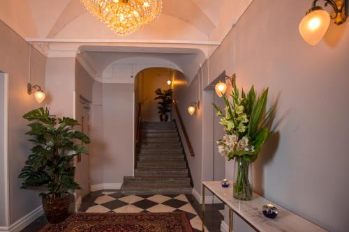 a hallway with a staircase with flowers and a chandelier at Hotel Gamla Stan, BW Signature Collection in Stockholm