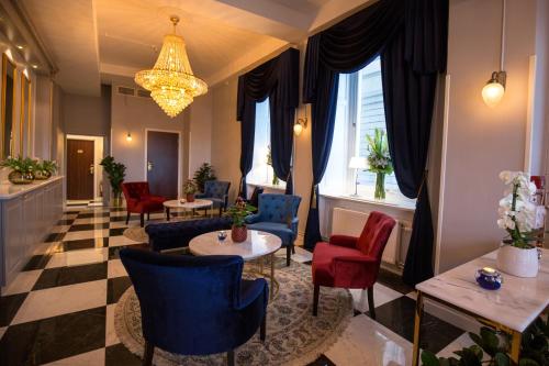 a waiting room with chairs and tables and a chandelier at Hotel Gamla Stan, BW Signature Collection in Stockholm