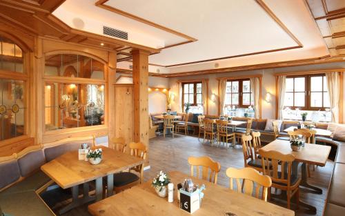 Rückersbacher Schlucht في Johannesberg: مطعم بطاولات وكراسي خشبية