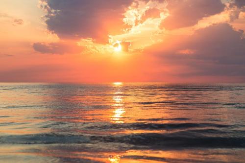 a sunset over the ocean on a beach at Villa Bougenvilia Tomas in Tučepi