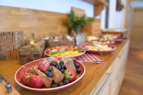 a buffet with plates of food on a counter at Bacherhof in Sankt Anton am Arlberg