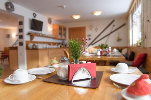 a table with white plates and a red napkin on it at Bacherhof in Sankt Anton am Arlberg