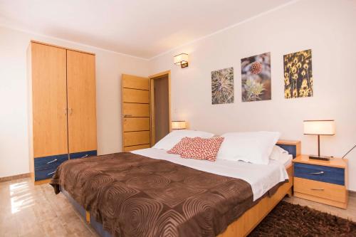a bedroom with a large bed and two pictures on the wall at Apartments Romano in Rovinj