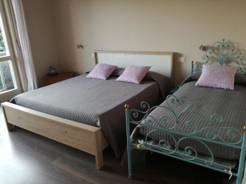 een slaapkamer met 2 bedden met paarse kussens bij Casale Antaldo in Nebbiuno