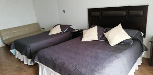 a bedroom with two beds with pillows at Hotel Del Valle Quilimari in Pichidangui