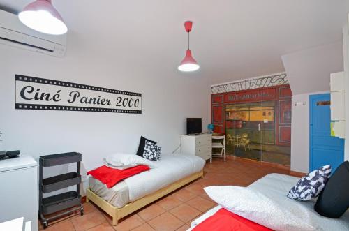 マルセイユにあるStudio Panier 2000のベッド2台が備わる客室で、壁に看板が付いています。