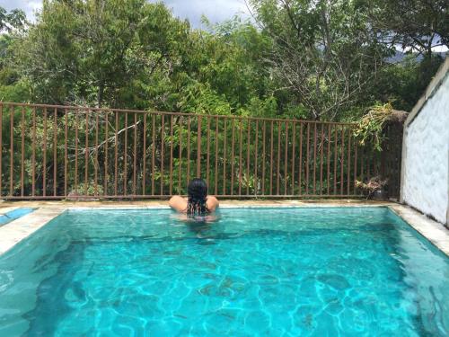 a woman sitting in a swimming pool at Hostel Café in Alto Caparao