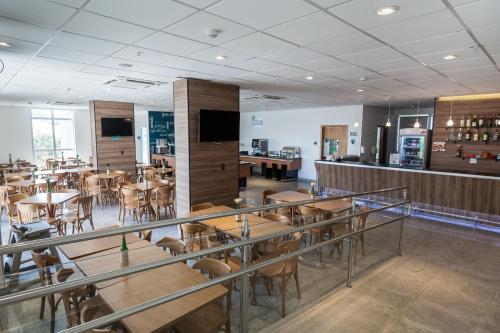 a restaurant with tables and chairs and a bar at San Diego Express Barro Preto in Belo Horizonte