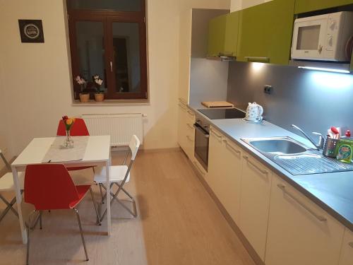 a kitchen with a table and a table and a table and a kitchen with at KaVi apartments #2 in Plzeň