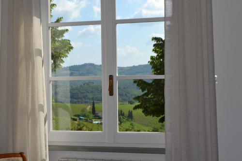 a window with a view of a green field at Terre di Melazzano - Le Case di Chiara in Greve in Chianti