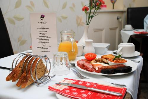 une table avec une assiette de nourriture et une assiette de produits pour le petit-déjeuner dans l'établissement BELL CRAIG GUEST HOUSE, à Fife