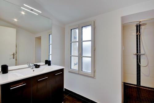 bagno con lavandino, finestra e doccia di Les Halles et Hauteurs by Cocoonr a Bordeaux