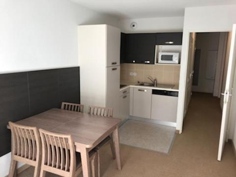 cocina con mesa de madera y sillas en una habitación en LE VALDAZUR 5 Avenue Saint-Bernard, en Valberg