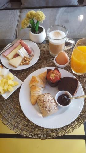 a table with plates of breakfast foods and drinks at In Porto Gallery Guesthouse in Porto