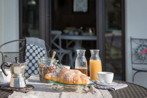una mesa con un plato de bollería y una taza de zumo de naranja en EDERA dei Guatto en Bertiolo