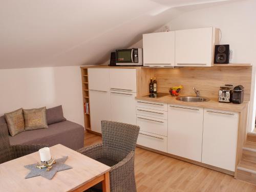 a kitchen and a living room with a table at Karwendel Apartments in Scharnitz