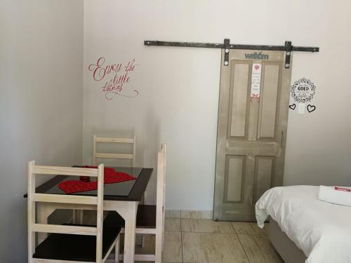 a room with a bed and a table and a door at Kalahari Rus in Upington