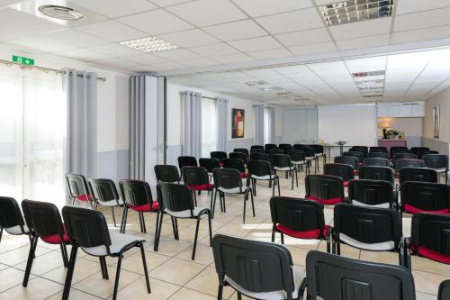 a room with rows of chairs in a room at The Originals City, Hôtel Le Pavillon, Béziers Est in Béziers