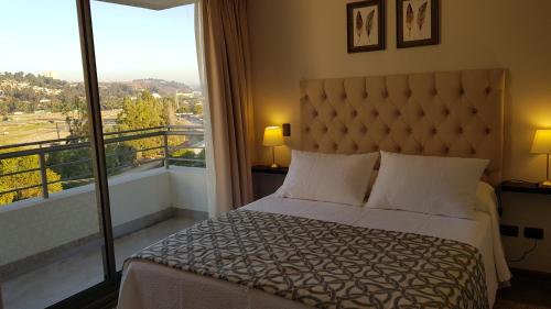 een slaapkamer met een bed en een groot raam bij Alto Sporting Apartments in Viña del Mar
