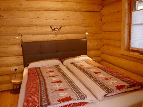 a bedroom with a bed in a log cabin at Karwendel Apartments in Scharnitz