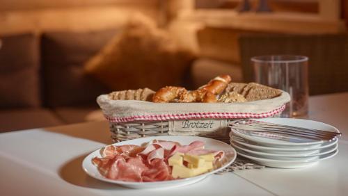 a basket of food on a table with a plate of food at Karwendel Apartments in Scharnitz