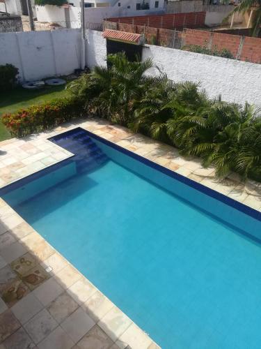 una gran piscina azul con palmeras en un patio en Casa Majorlandia en Majorlândia
