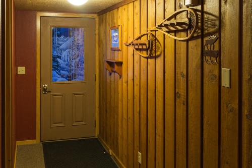 a hallway with wooden walls and a door at Faithful Street Inn in West Yellowstone