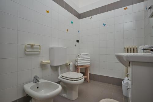 La salle de bains blanche est pourvue de toilettes et d'un lavabo. dans l'établissement Casa Manu, à Brenzone