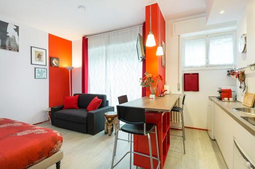 ミラノにあるAppartamento Rosso a Milano, tranquillo, vicino allo IEOのベッド1台、キッチン(テーブル付)が備わる小さな客室です。