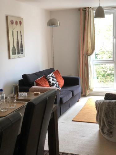 a living room with a blue couch and a table at Sky Night Serviced Apartments in Cardiff