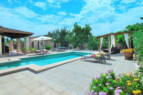 a swimming pool in a backyard with a table and chairs at Owl Booking Villa Gabelli - Rustic Stay with Great Views in Campanet