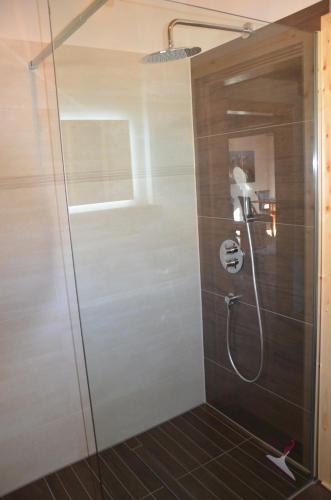 a shower with a glass door in a bathroom at Ferienwohnung im Landhausstil in Missen-Wilhams