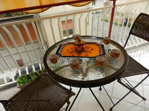 a glass table on a balcony with two chairs at B&B Joe in Valguarnera Caropepe