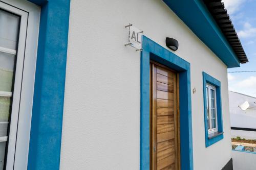 a house with blue trim and a door at Quinta do Oeste in Doze Ribeiras