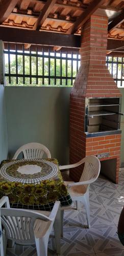 a patio with a table and chairs and a brick oven at Casa da Cachoeira in Brotas