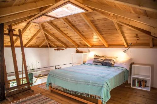 a bedroom with a bed in a room with wooden ceilings at Piges in Milína