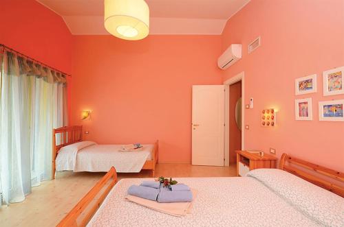 een slaapkamer met 2 bedden en oranje muren bij Rosa Tea in Monteforte dʼAlpone