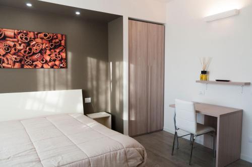 a bedroom with a bed and a desk and a painting at VILLA FENIX PONTE SAN PIETRO in Ponte San Pietro