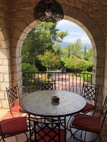 un patio avec une table et des chaises sur un balcon dans l'établissement Villa La Pastorale, à Saint-Paul-de-Vence