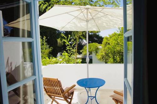 a patio with a blue table and an umbrella at Giannakis Filoxenia in Philotium