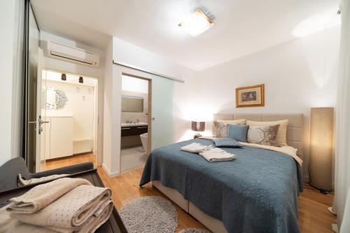 a bedroom with a large bed and a bathroom at Apartment Garden Terrace in Zadar