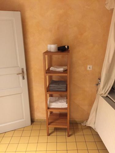 a wooden shelf with towels on it in a bathroom at Himmel & Hölle in Quedlinburg