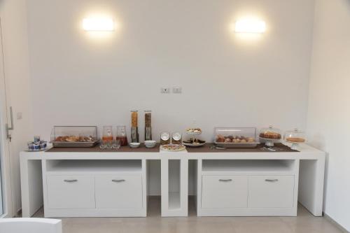 ein Tisch mit Tellern voller Essen in der Unterkunft B&B Rose in Porto Cesareo