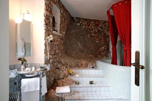 a bathroom with a sink and a stone wall at La Locanda Delle Donne Monache in Maratea