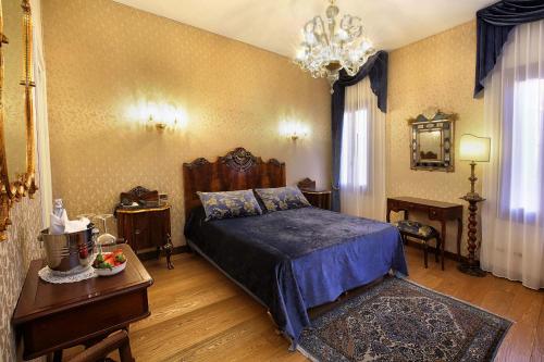 a bedroom with a bed and a table and a chandelier at Ca' Pagan in Venice