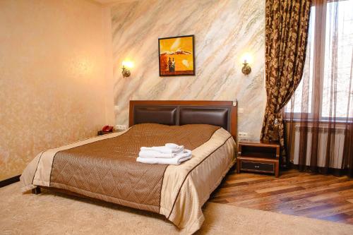 a bedroom with a bed with towels on it at Totem Hotel in Shymkent