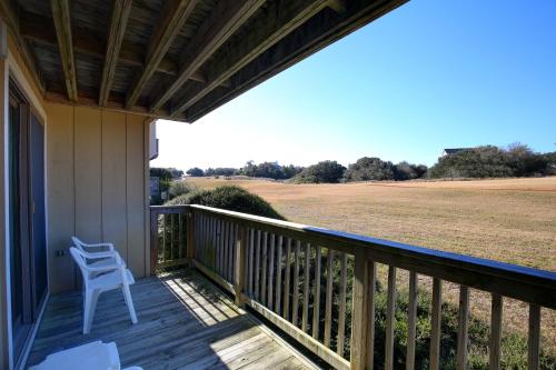 a porch with a white chair and a field at Sea Scape Beach and Golf Villas in Kitty Hawk