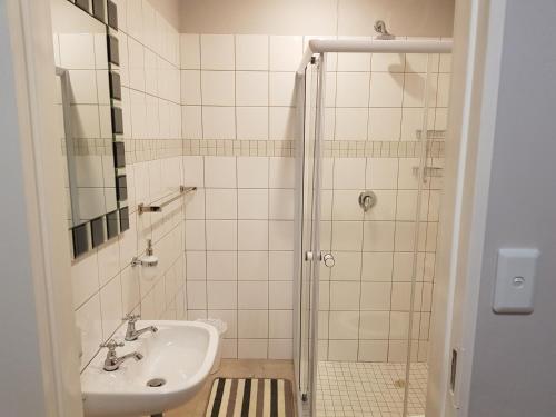La salle de bains est pourvue d'un lavabo et d'une douche. dans l'établissement RY Courtyard, à Oshakati