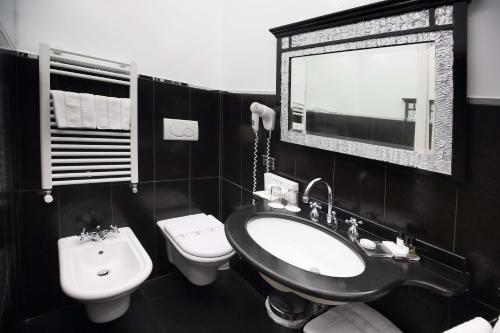 a bathroom with a sink and a toilet and a mirror at Ca' Pagan in Venice