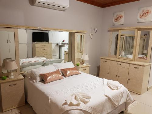 a large bedroom with two beds and a mirror at RY Courtyard in Oshakati